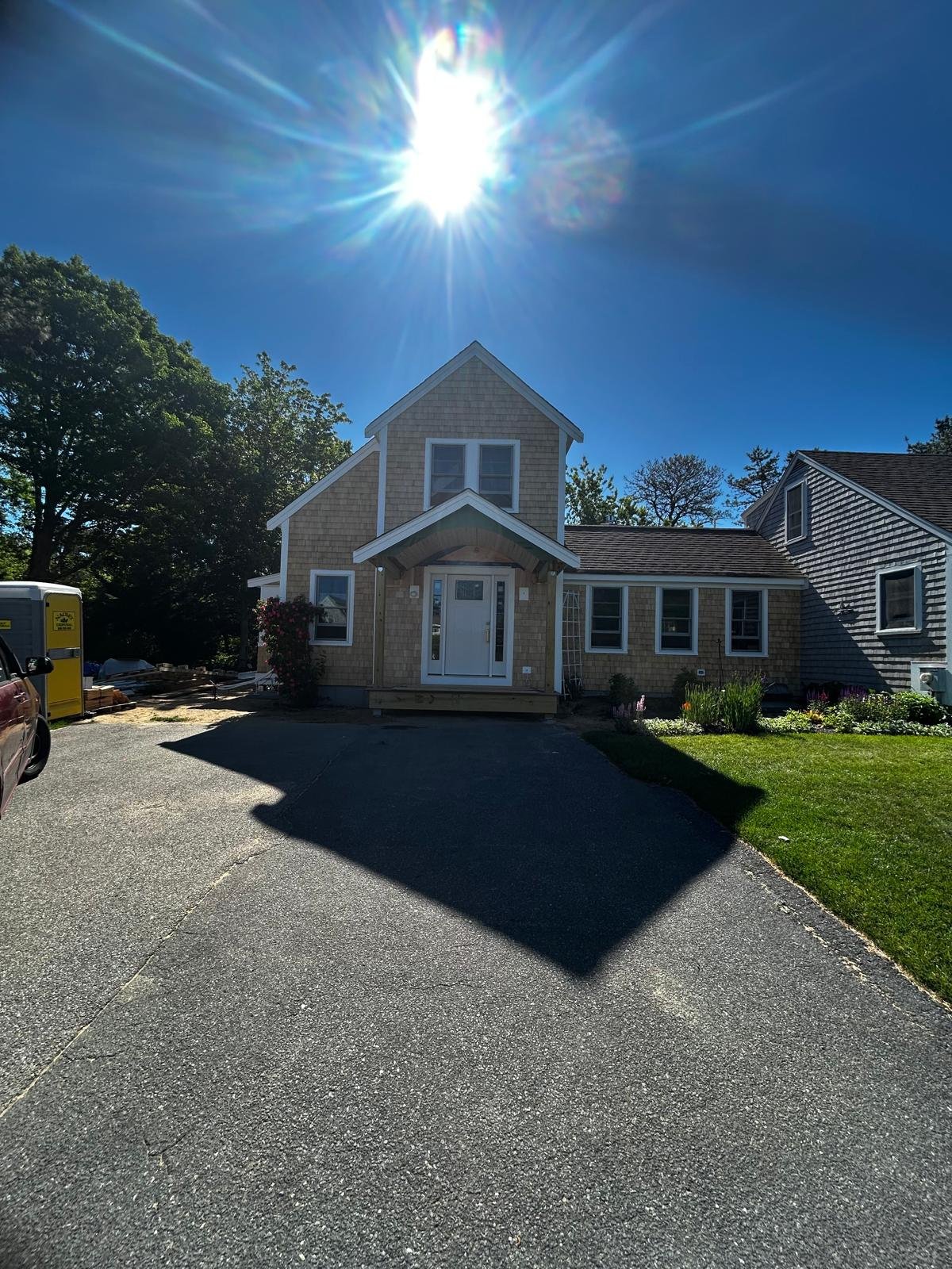 The same house finished, with cedar shingles and a white front entry portico